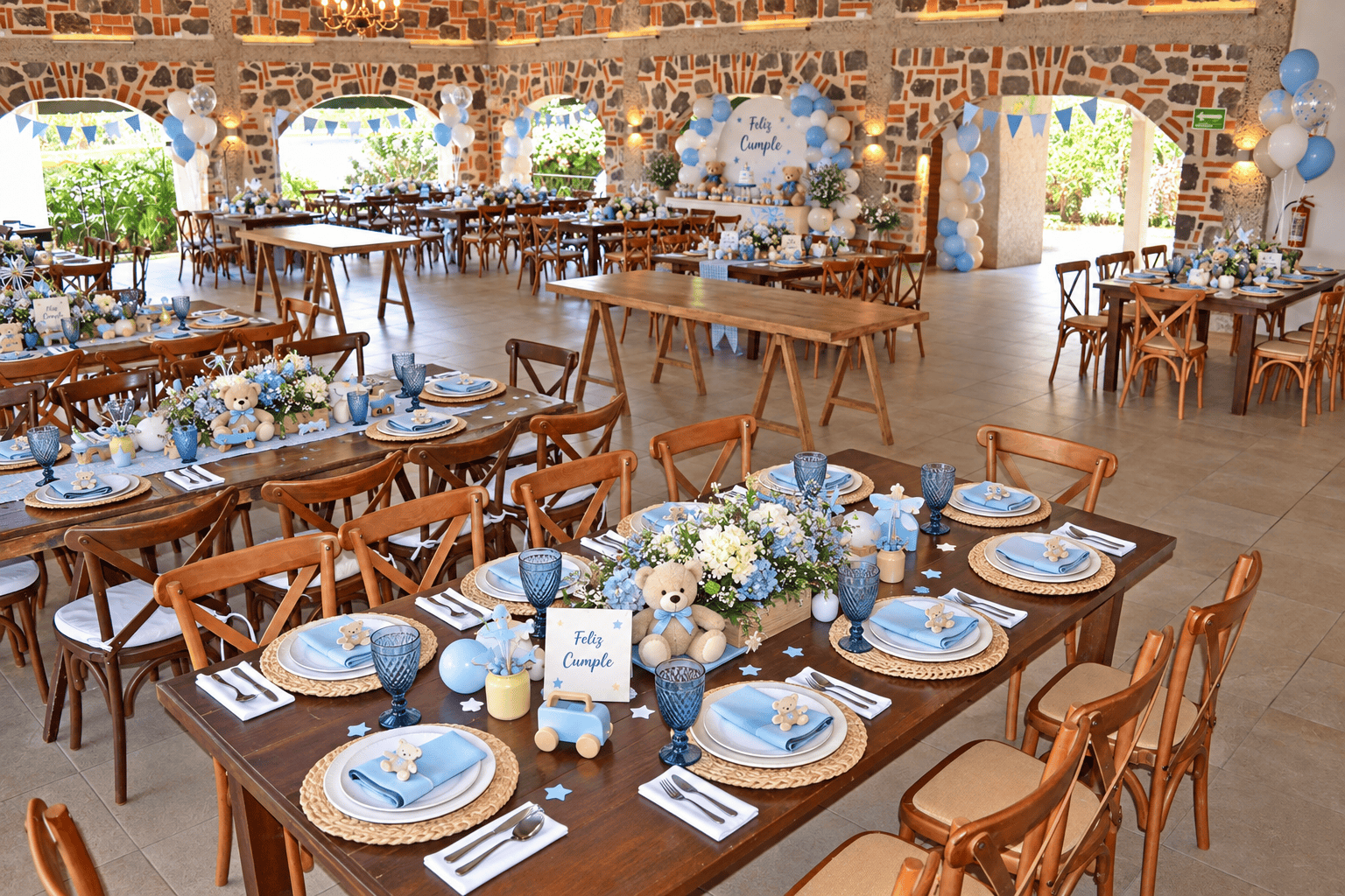 Salón ambientado para cumpleaños en tonos azules con mesas de madera, osos de peluche, globos y letrero Feliz Cumple