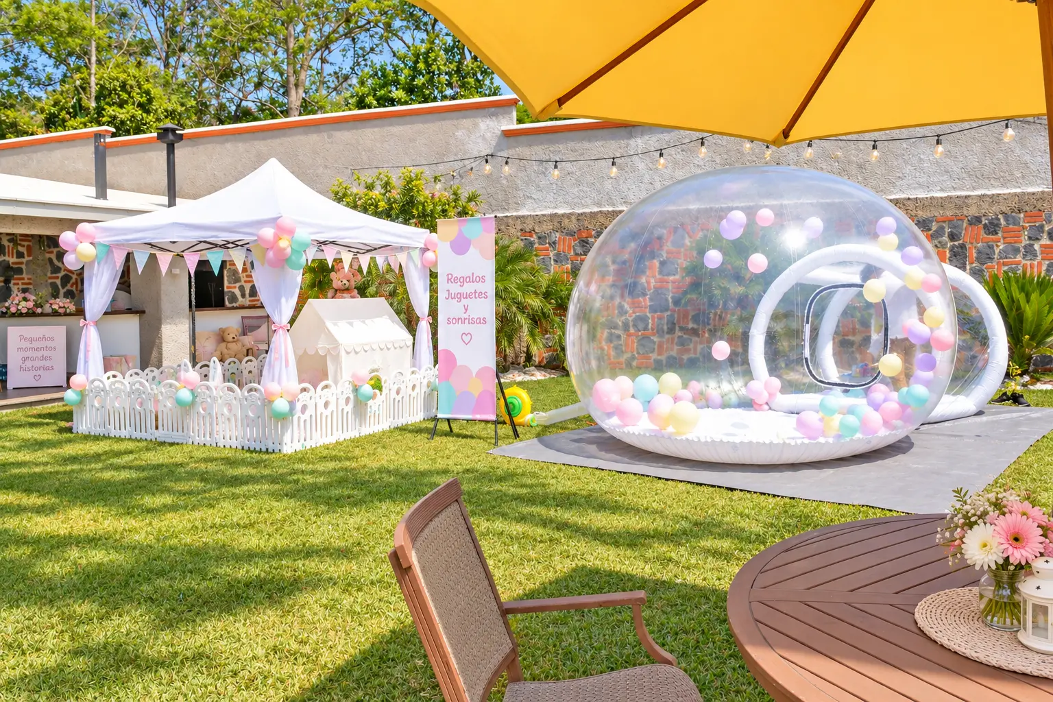 Jardín ambientado para fiesta infantil con carpa blanca, globos pastel, burbuja inflable y mesa de regalo