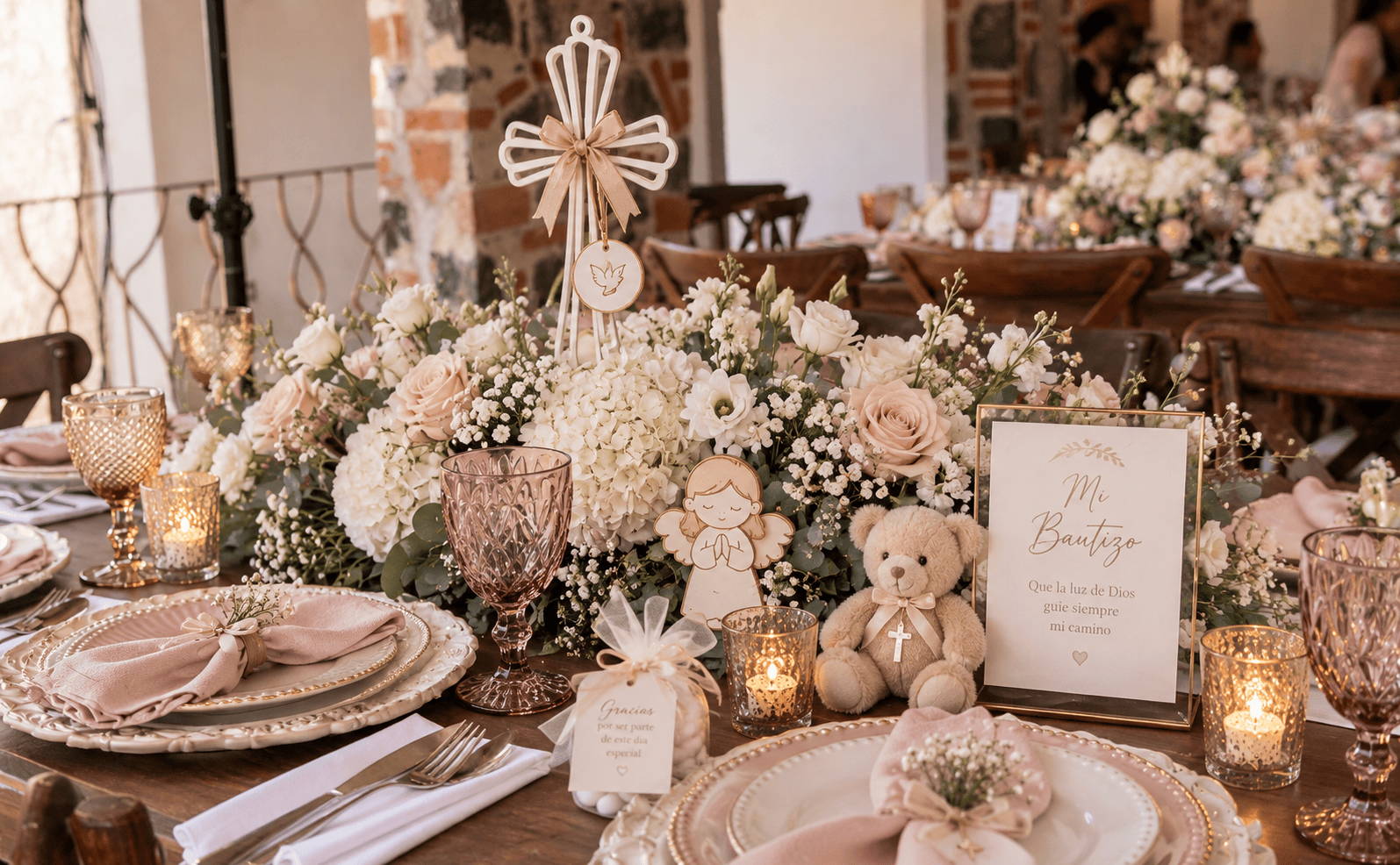 Mesa de banquete ambientada para bautizo con flores, cruz decorativa y detalles en tonos rosa