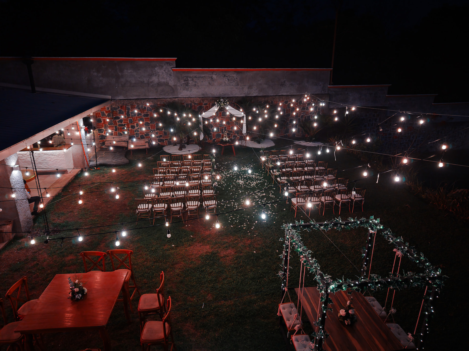 Jardín iluminado con series de luces para una celebración nocturna