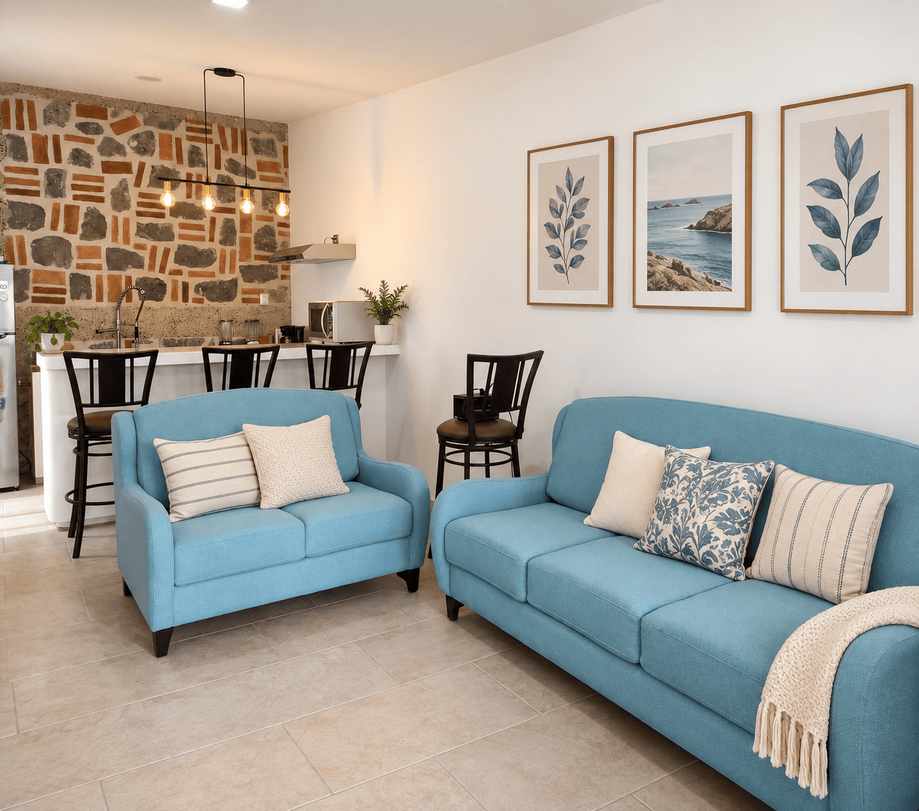 Sala del bungalow con sofás azules, barra de desayuno y muro de piedra